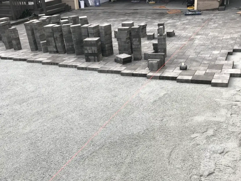 Paver blocks staged for an in-progress patio installation