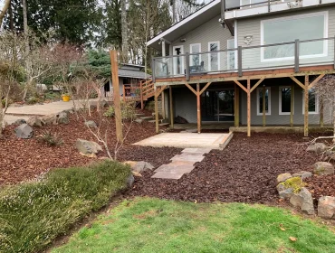 Finished flagstone patio with deck and backyard landscaping