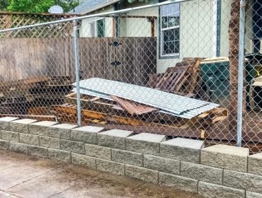 Block retaining wall corner near a fence